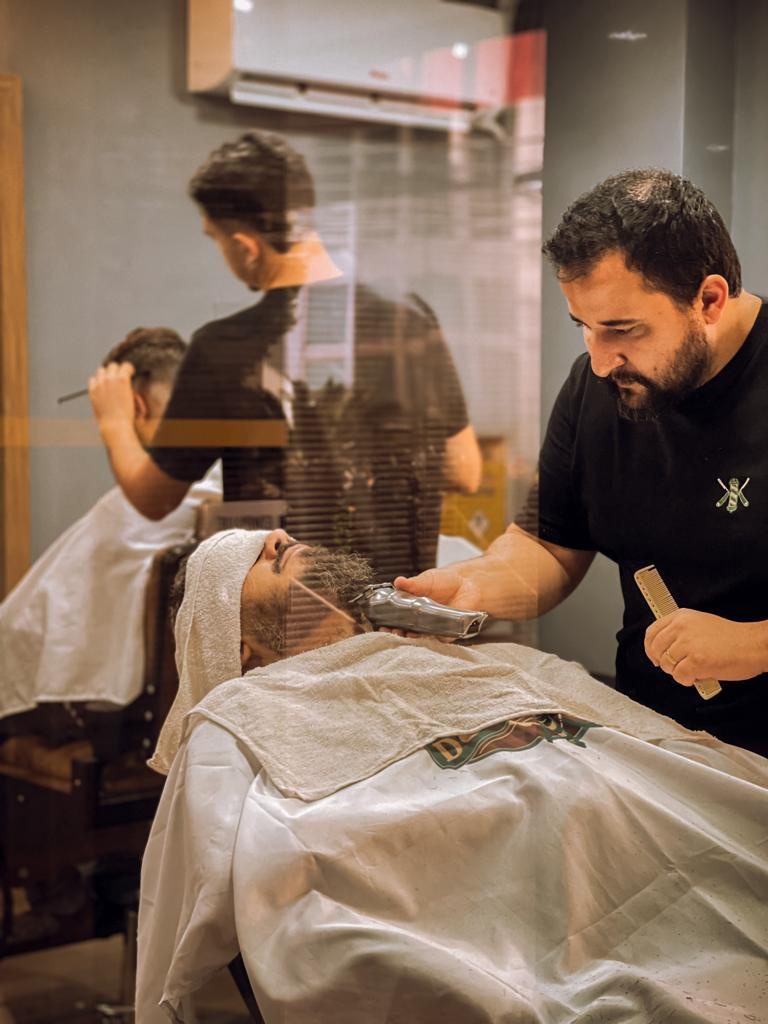 Equipe atendendo clientes no salão da Barbearia do Patrão